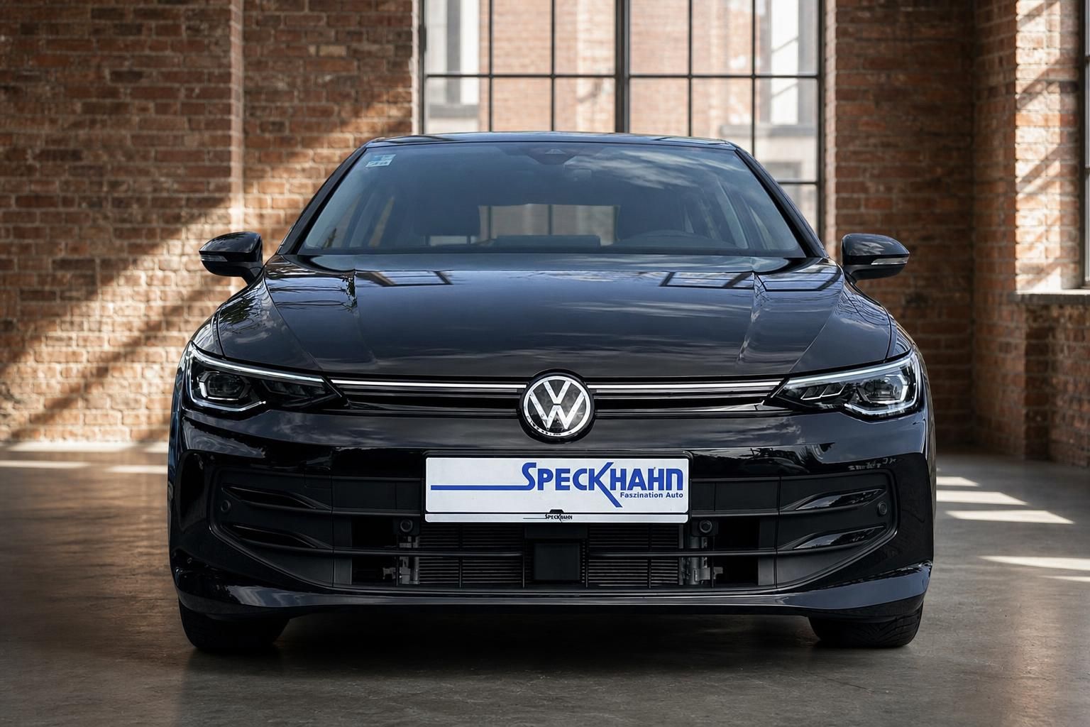 VW Golf schwarz Frontansicht mit LED-Scheinwerfern in Industriehalle