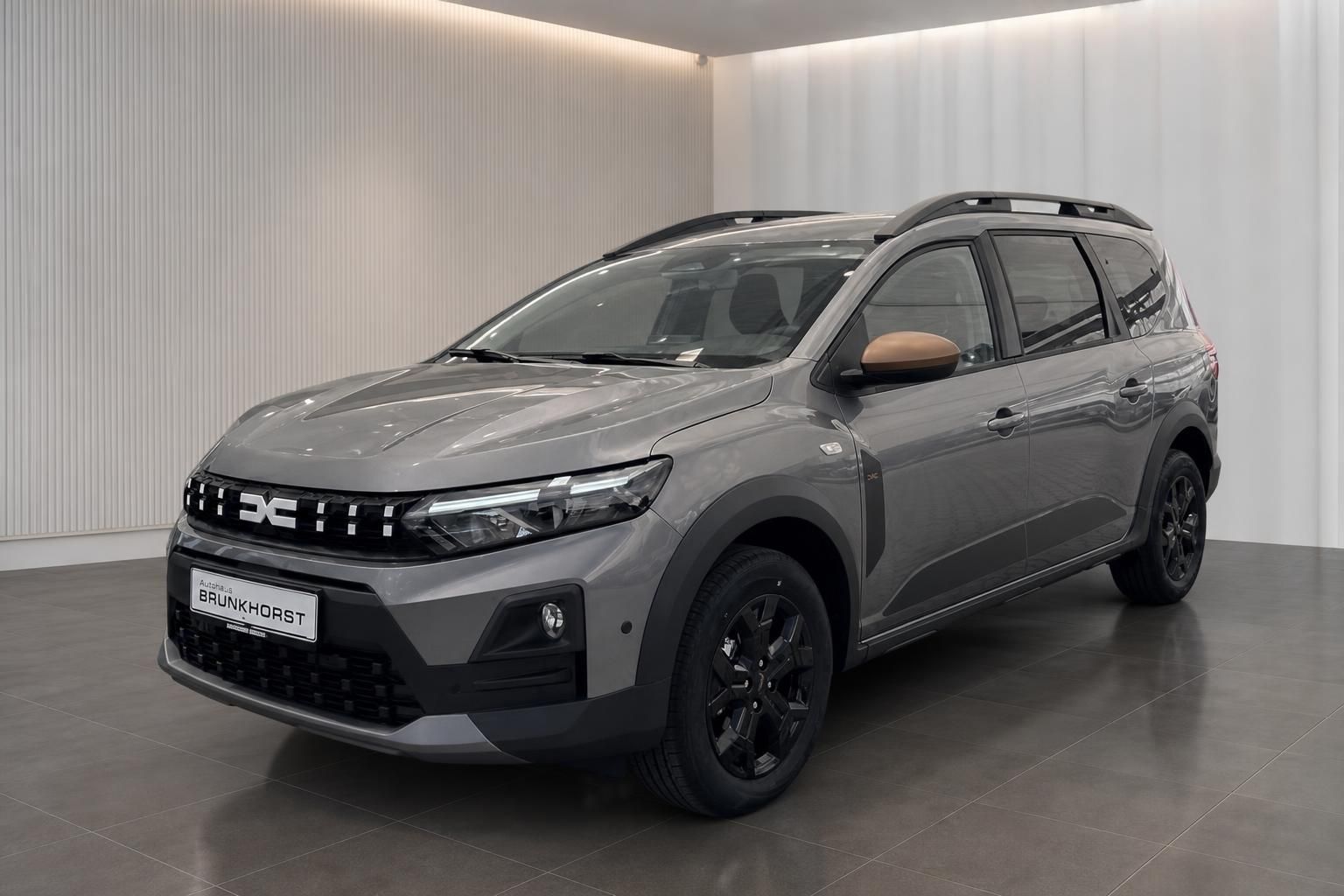 Grauer SUV Seitenansicht mit schwarzen Felgen im Autohaus-Showroom