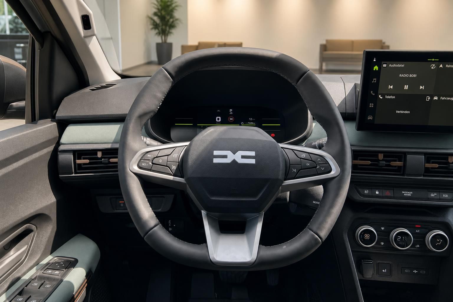 Innenraum eines Fahrzeugs mit Lenkrad und Infotainment-Display