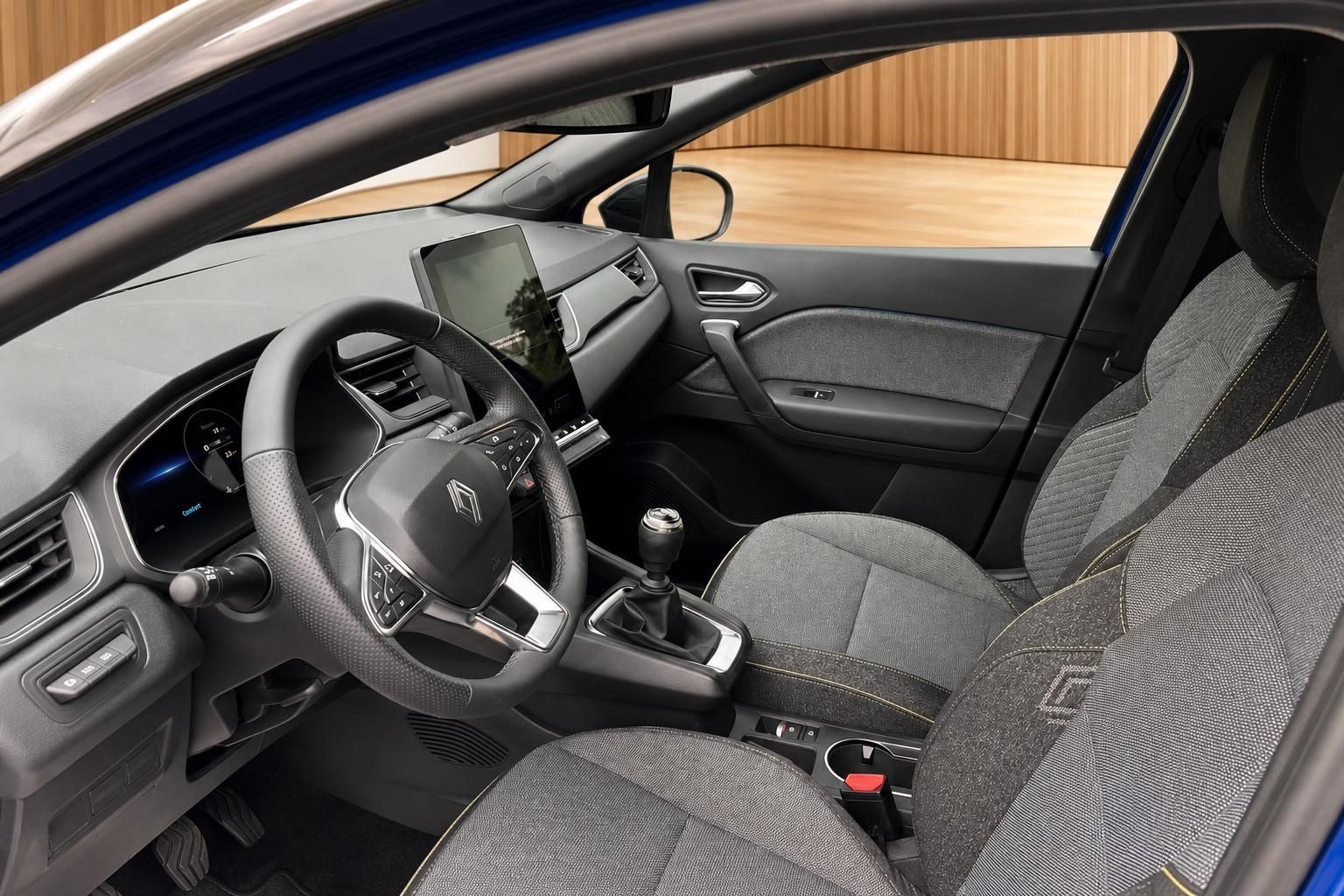 Renault Innenraum mit Lenkrad, Touchscreen, Schaltgetriebe und Stoffsitzen in Grau