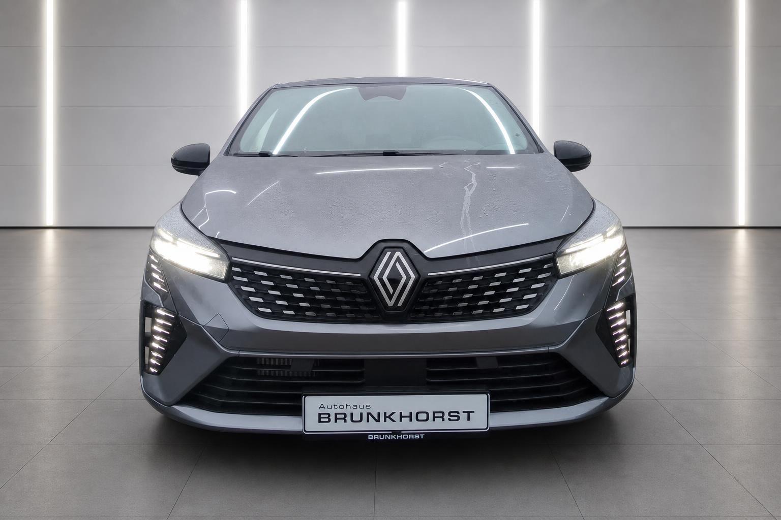 Renault Clio grau Frontansicht mit charakteristischem Kühlergrill und LED-Tagfahrlicht im Showroom