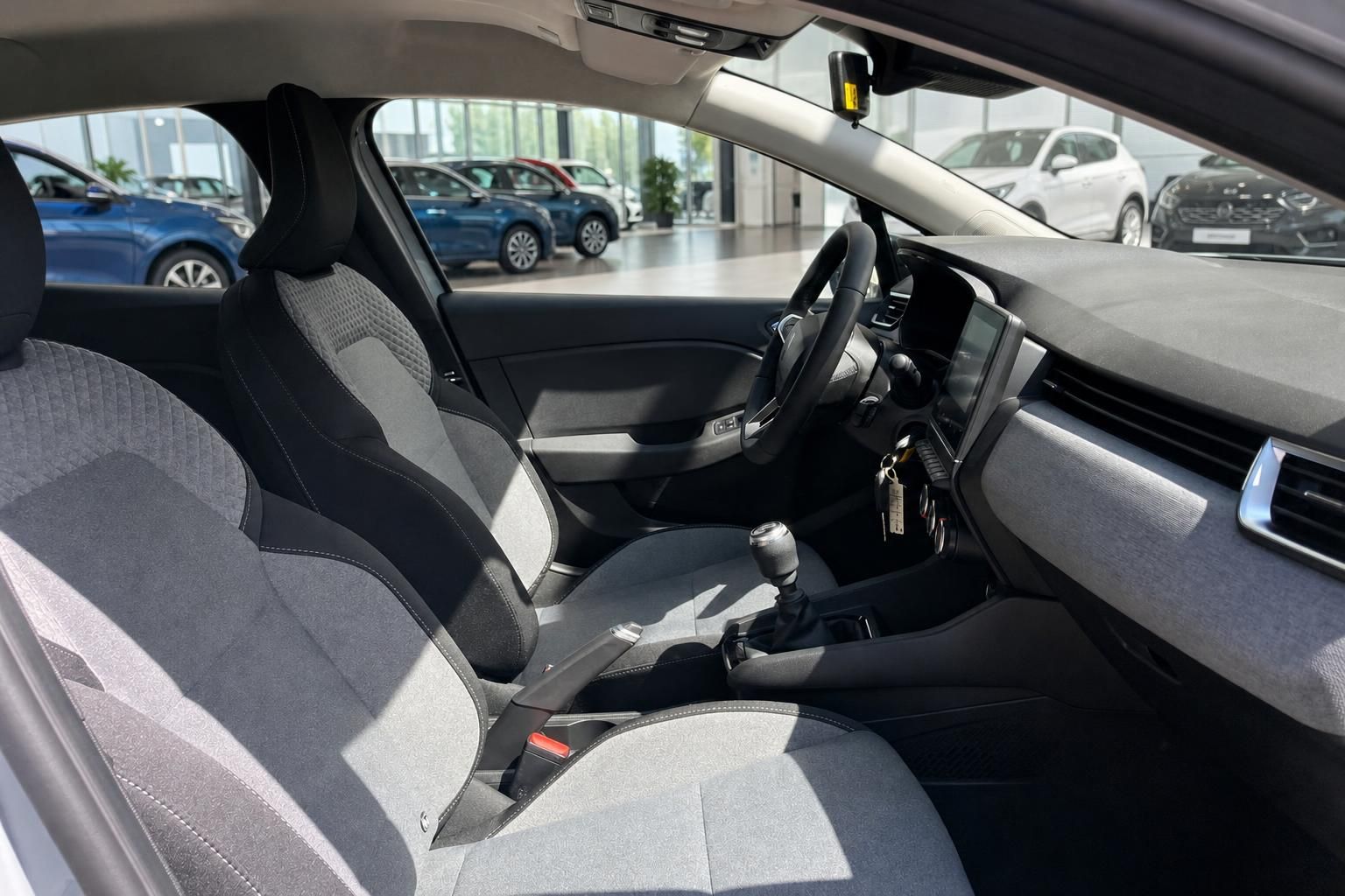 Renault Clio Innenraum – Vordersitze mit grau-schwarzem Stoffbezug und Schaltgetriebe