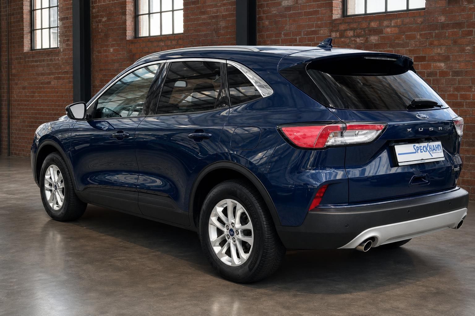 Ford Kuga dunkelblau Heckansicht seitlich in Loft-Ambiente