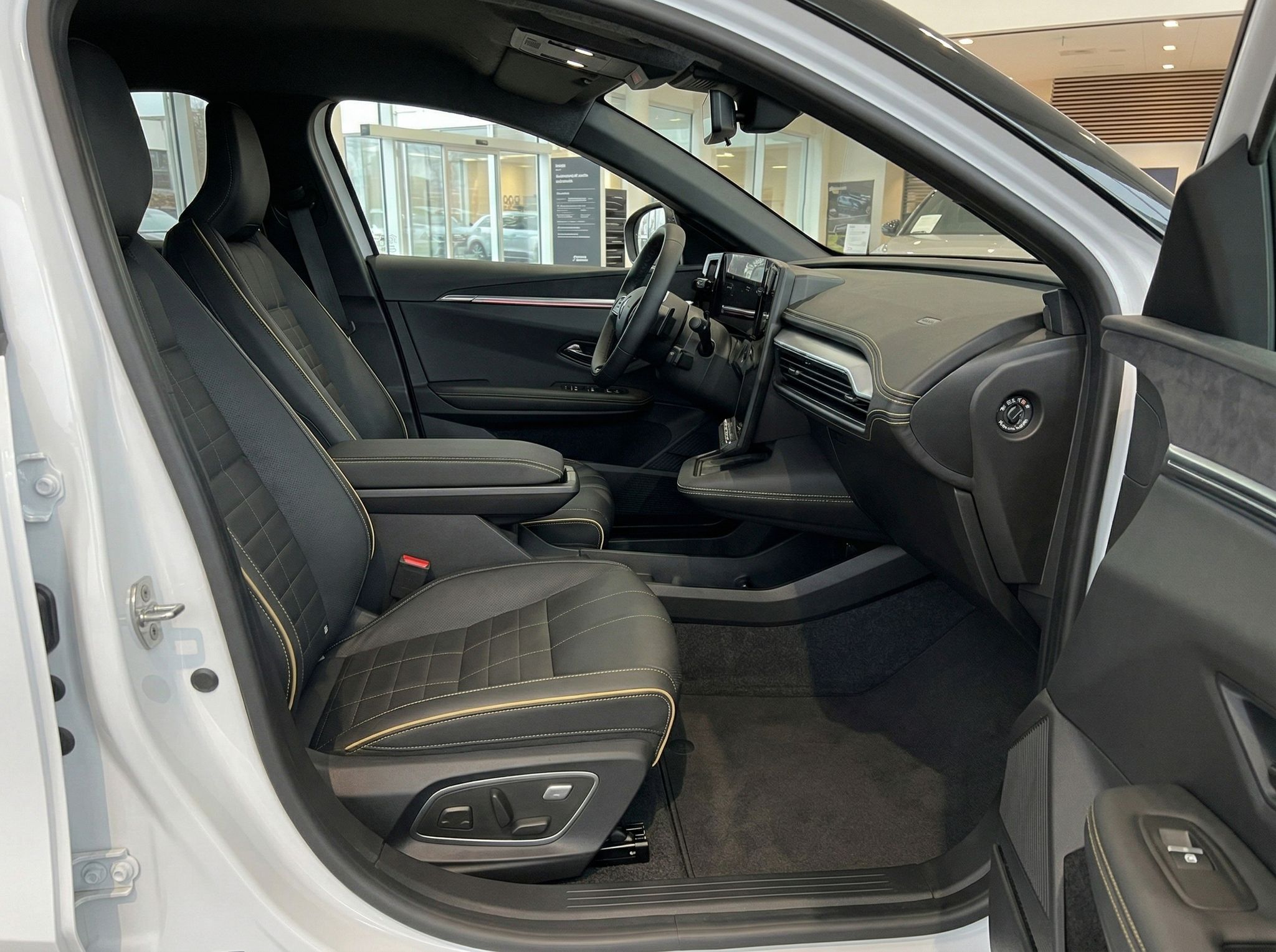 Fahrzeuginnenraum mit grauen Ledersitzen und offenem Beifahrerbereich