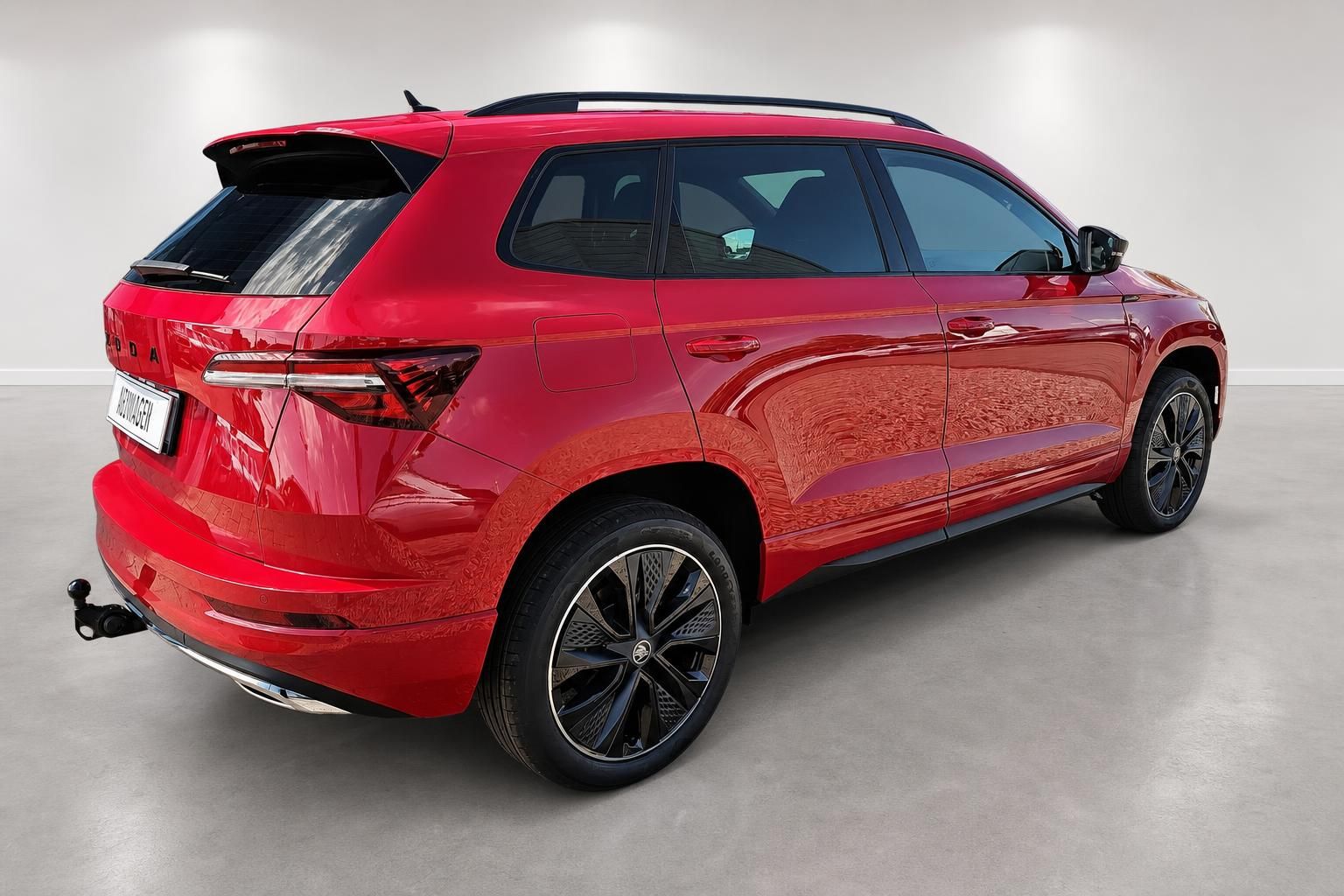 Roter Skoda Karoq, Heck-Seitenansicht mit Anhaengerkupplung