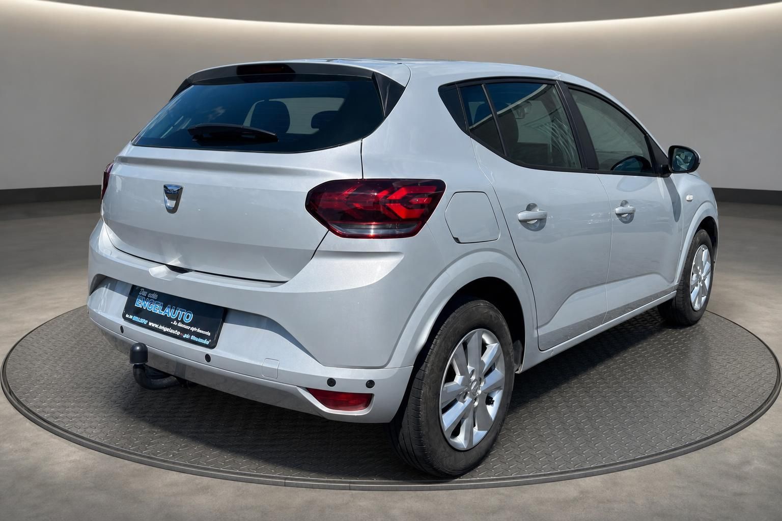 Dacia Sandero Heck-Seitenansicht silber mit Alufelgen und elegantem Heckdesign auf Drehscheibe