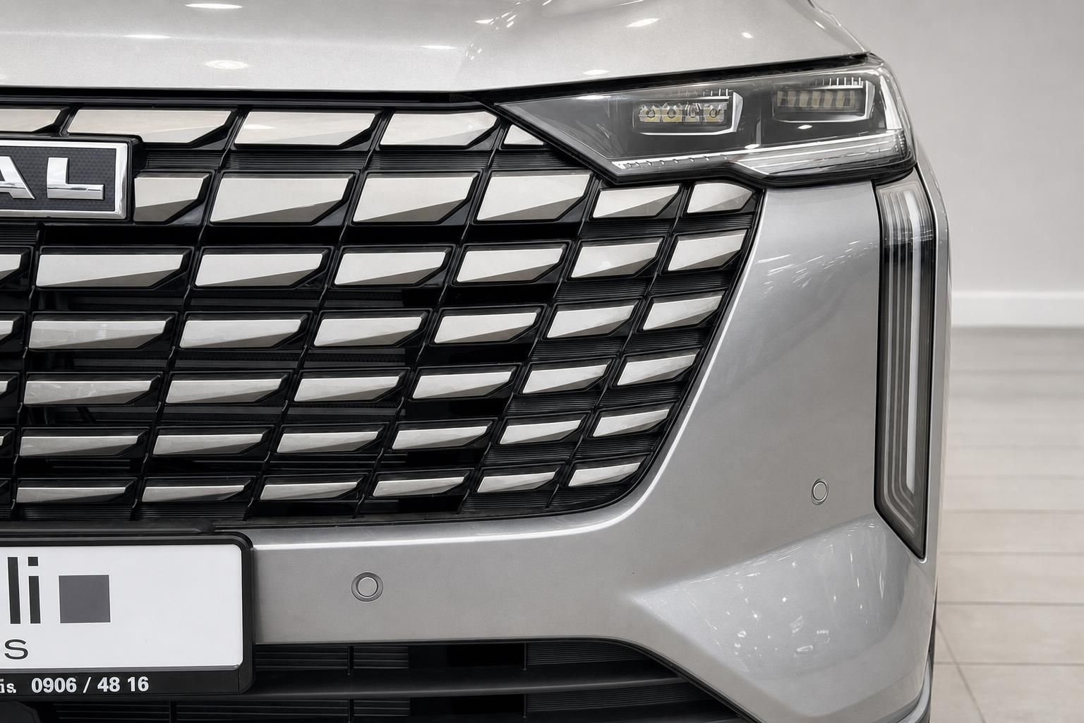Frontdetail mit Kühlergrill und LED-Scheinwerfer eines silbernen SUV