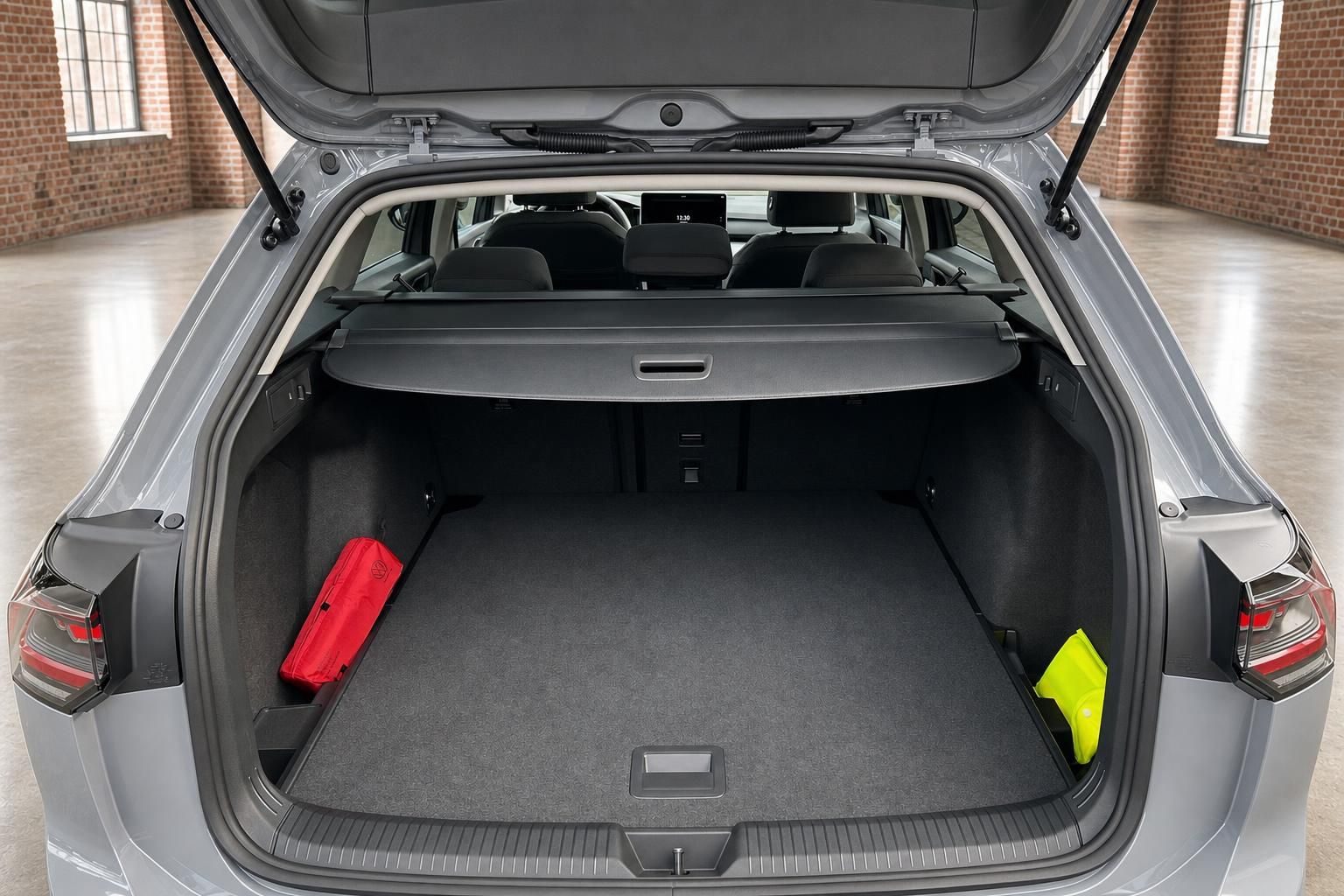 VW Kombi Kofferraum geoeffnet mit Laderaumabdeckung und Zubehoer