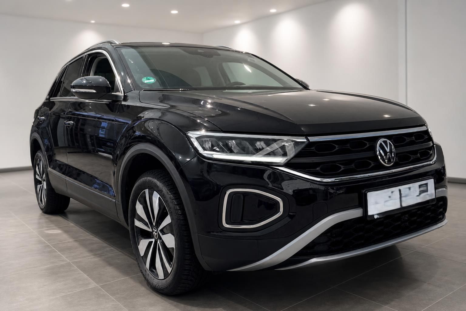 VW T-Roc schwarz Frontansicht schräg links im Showroom – SUV mit Chromakzenten