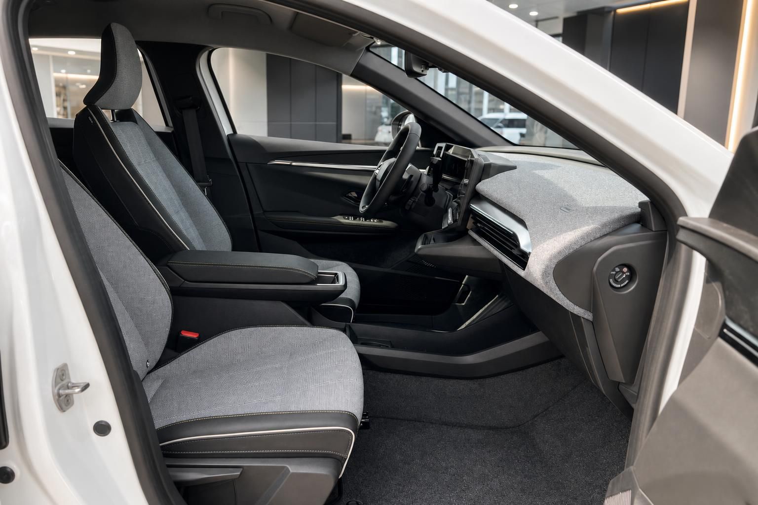 Vordersitze und Cockpit im Innenraum eines weißen Renault mit Stoff-Leder-Polster