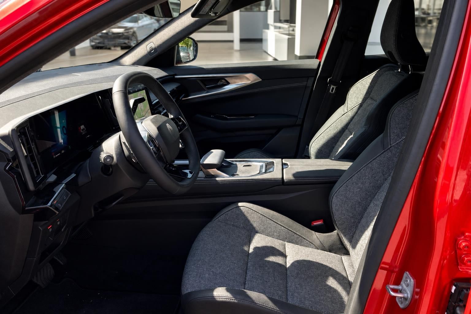 Innenraum SUV Fahrerseite – Lenkrad, Touchscreen, Mittelkonsole und Vordersitze in Grau