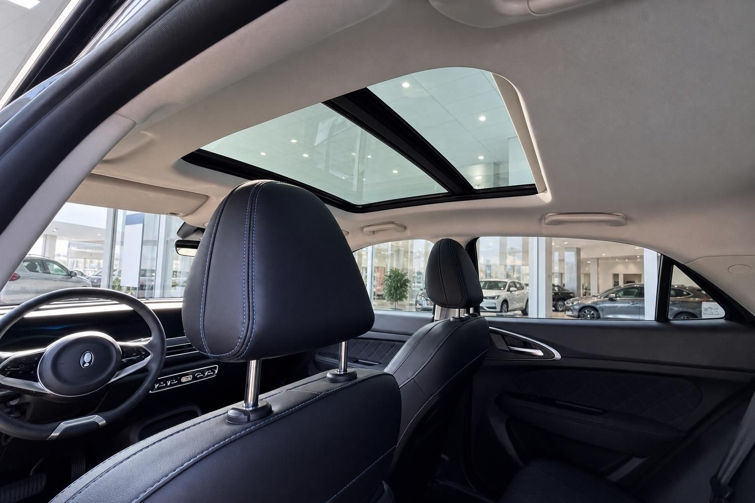 Fahrzeug Innenraum mit schwarzen Ledersitzen, Panorama-Schiebedach und modernem Design im Autohaus