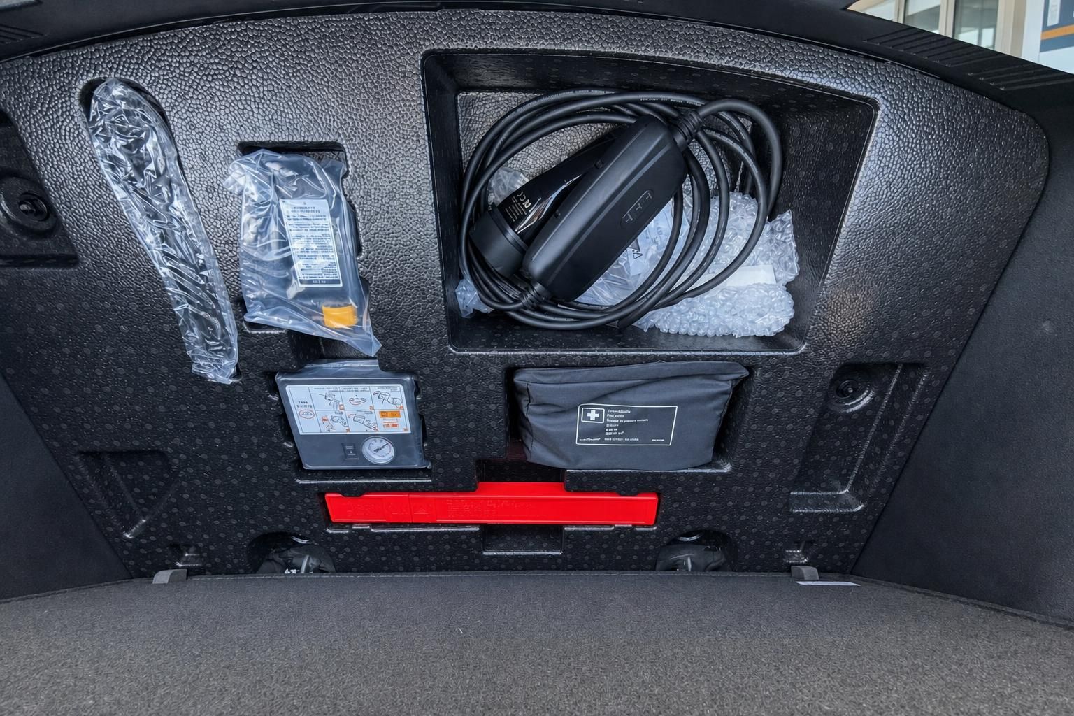 Kofferraum Ausstattung mit Ladekabel, Kompressor, Erste-Hilfe-Set und Bordwerkzeug im Elektrofahrzeug