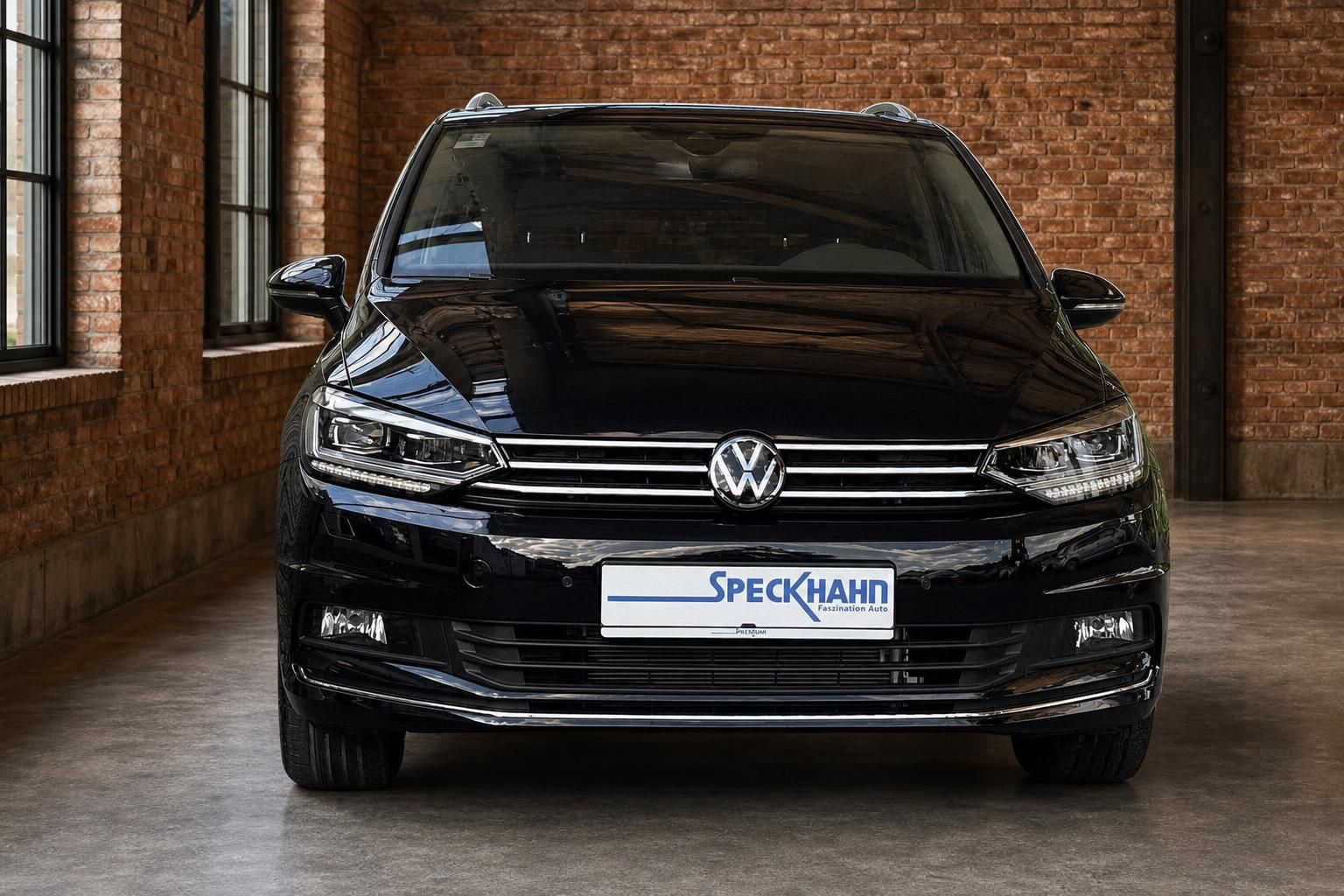 VW Touran schwarz Frontansicht in Industrieloft mit Backsteinwand