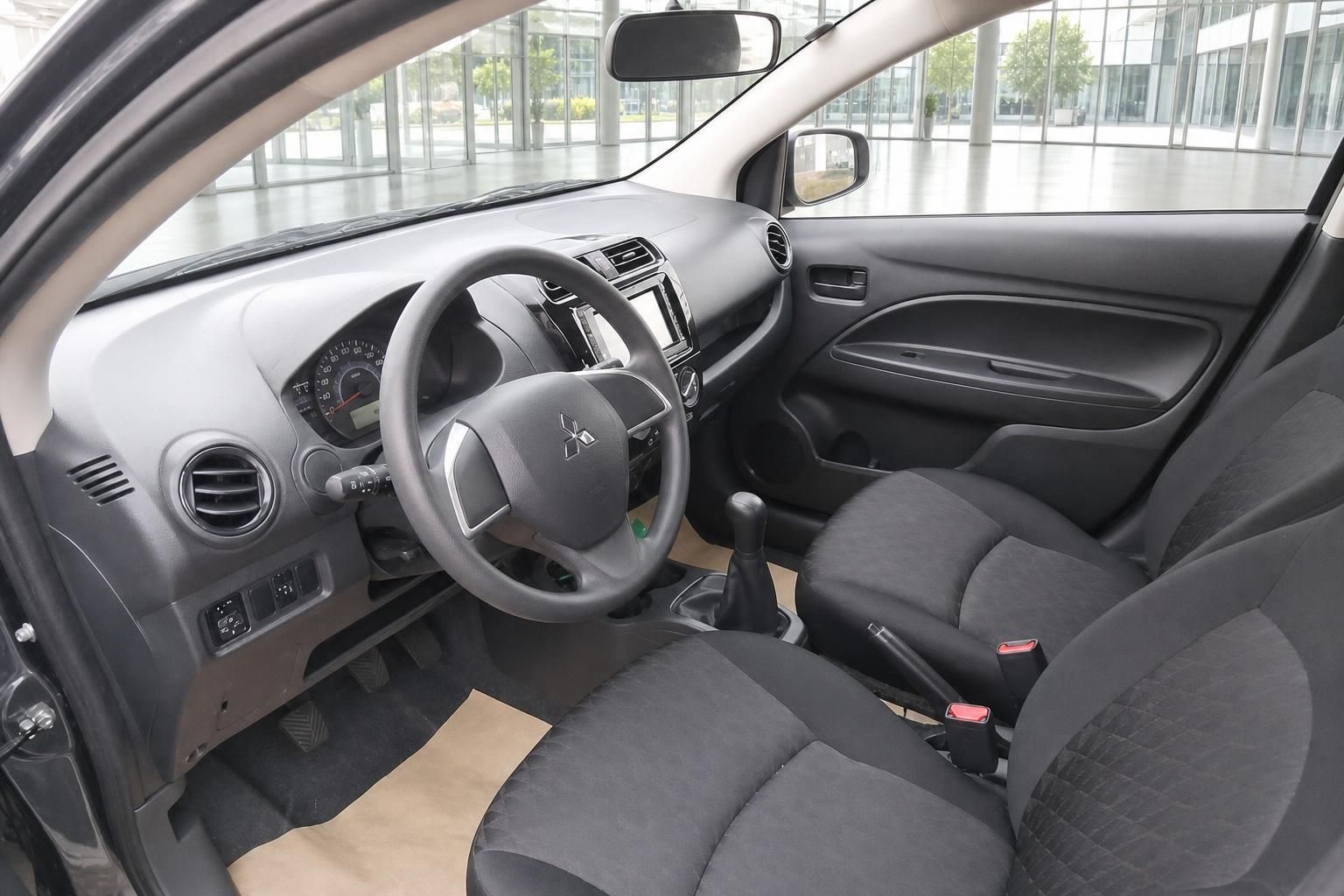 Mitsubishi Space Star Innenraum mit Lenkrad, Armaturenbrett und schwarzen Stoffsitzen