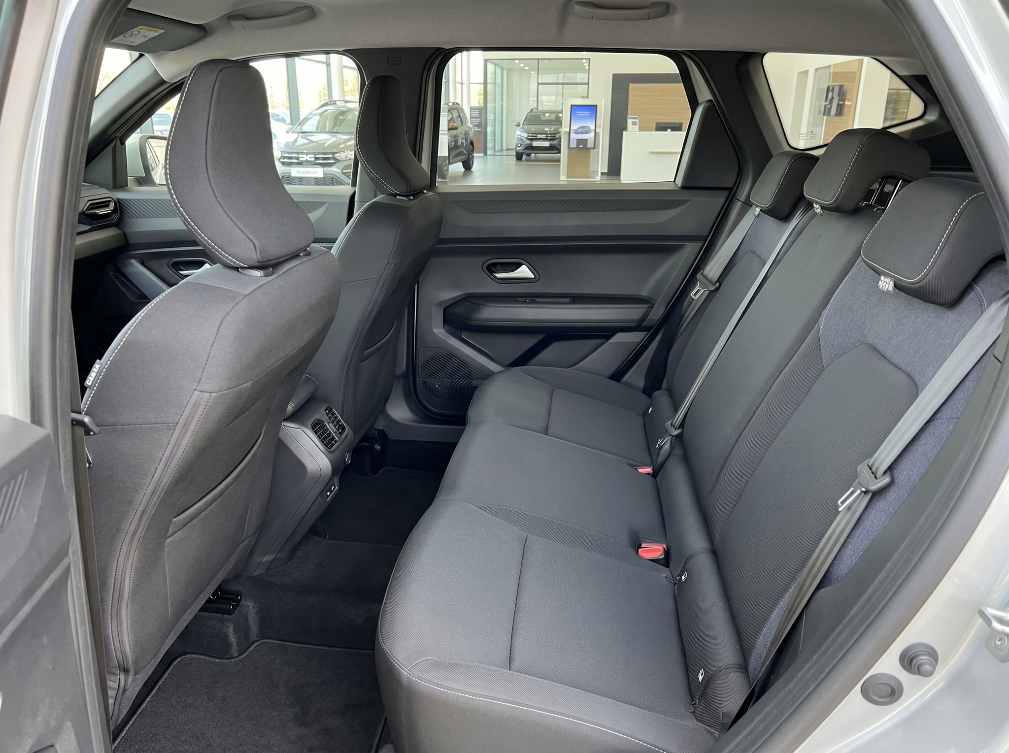 Rücksitzbereich PKW mit grauen Polstern und Dreipunkt-Sicherheitsgurten