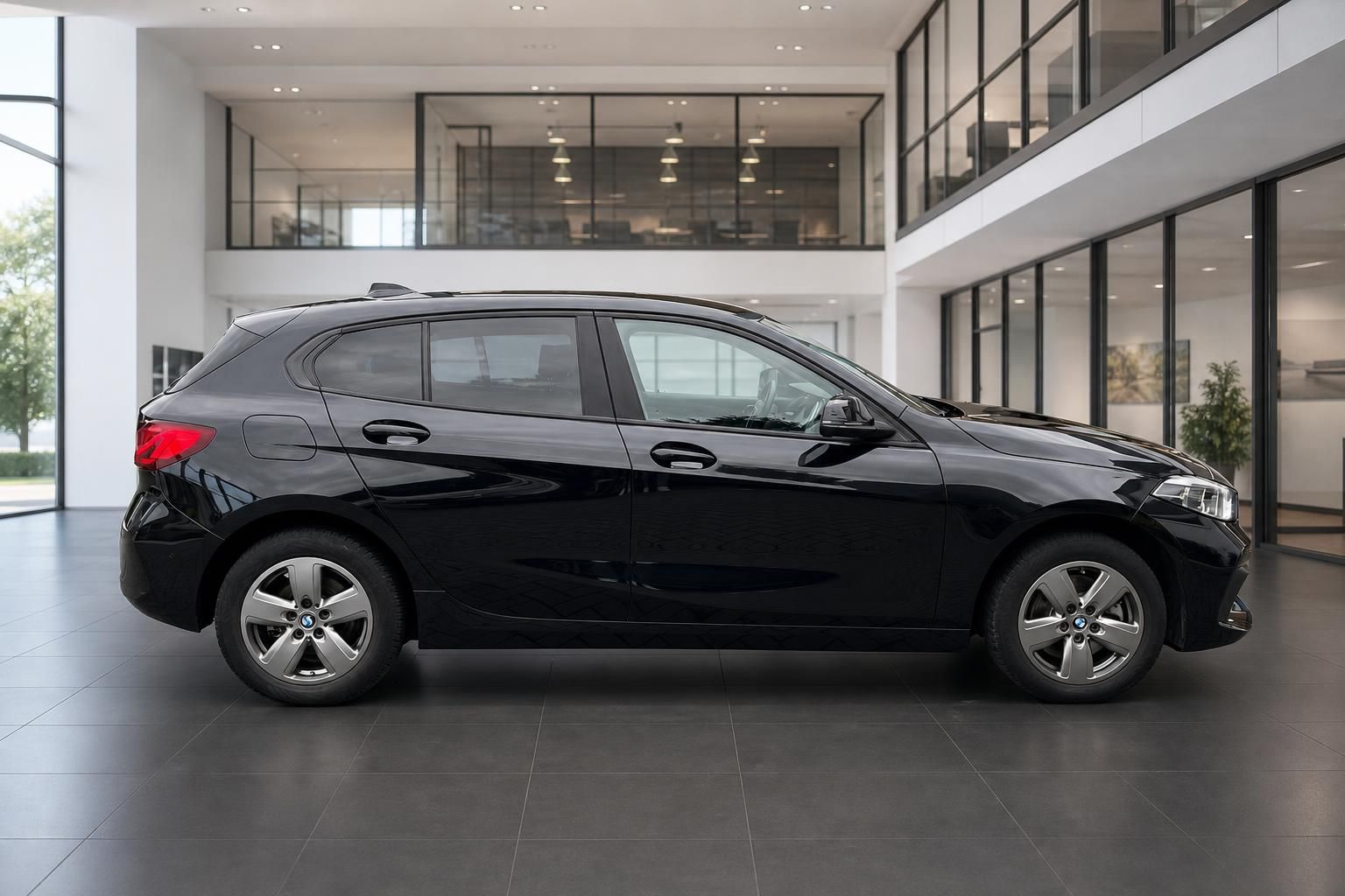 BMW 1er schwarz Seitenansicht im modernen Autohaus Showroom
