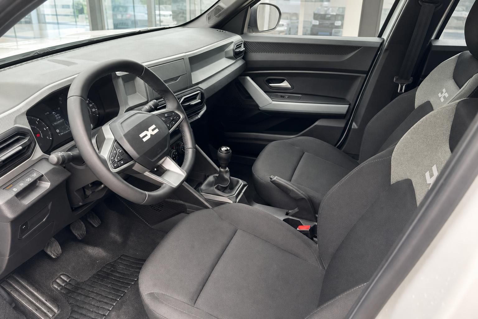 Innenraum Dacia mit schwarzem Cockpit, Lenkrad und manueller Schaltung