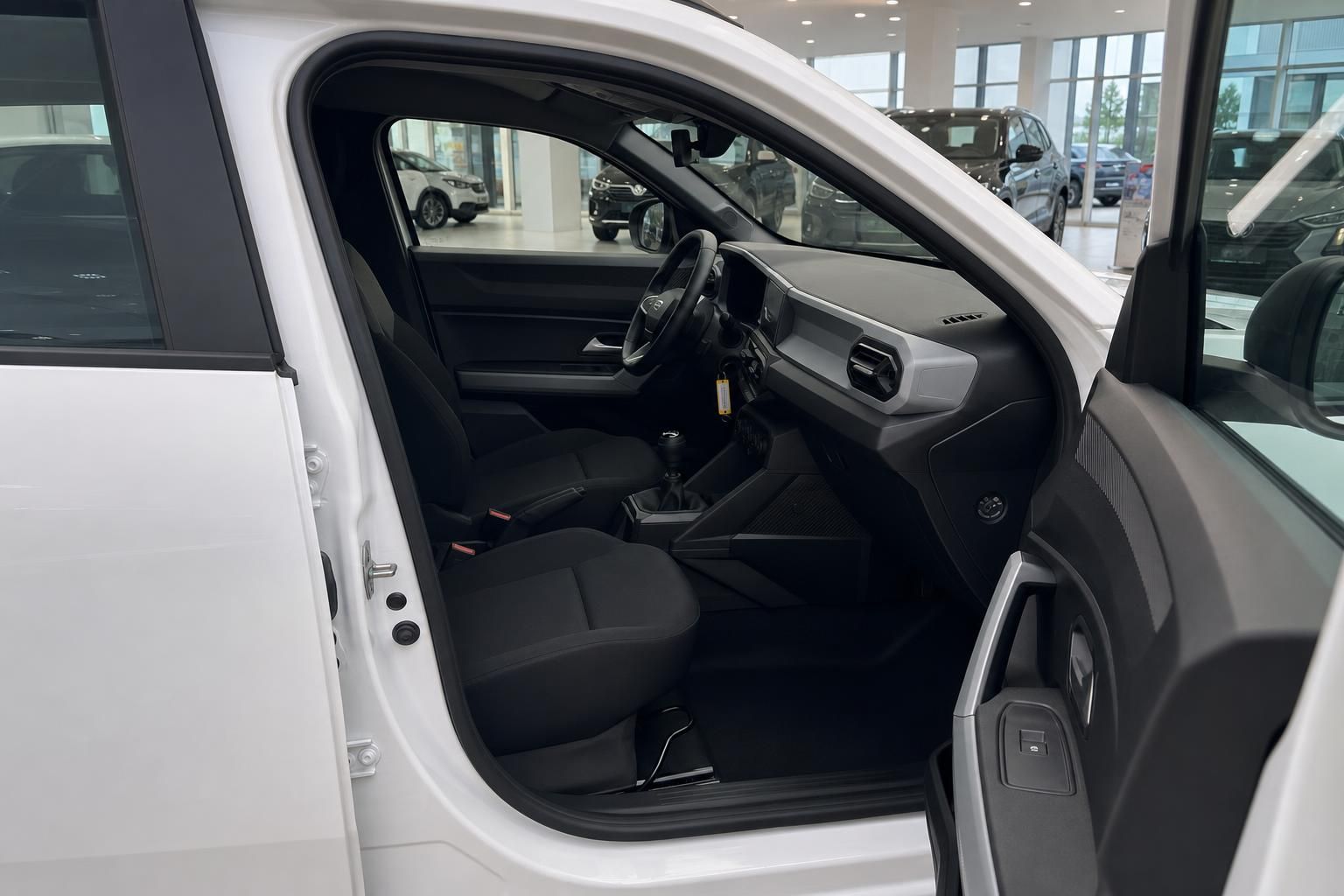 Weißer PKW Innenraum mit schwarzer Ausstattung und Blick auf Fahrersitz im Autohaus