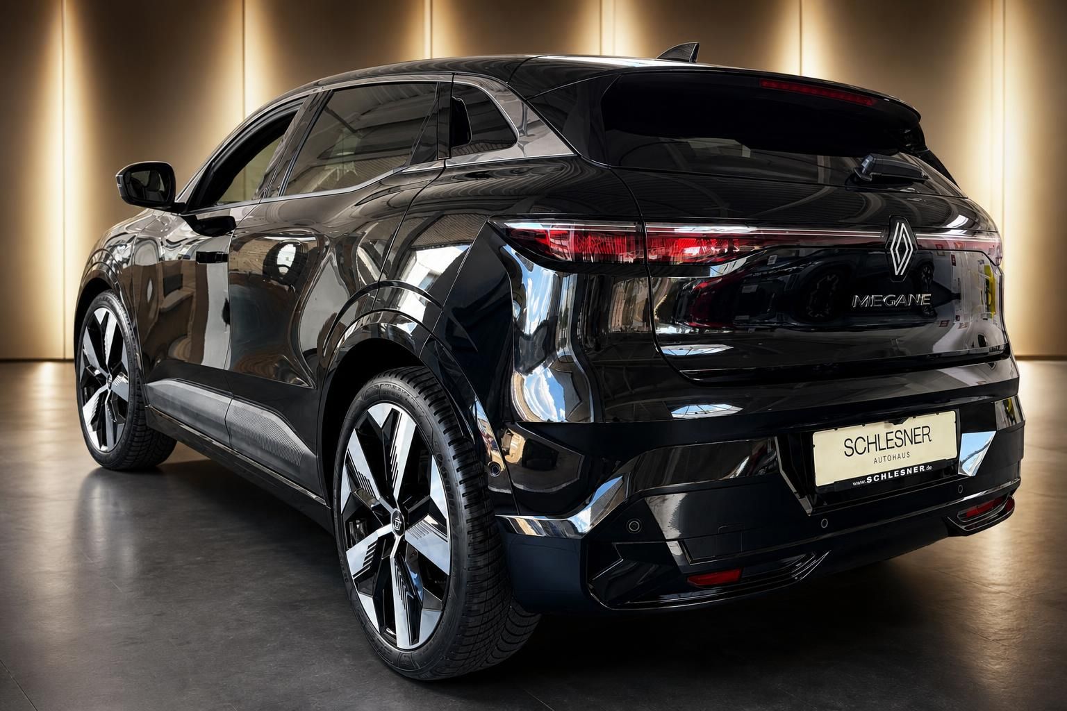 Renault Megane E-Tech schwarz, Heckansicht seitlich im Showroom