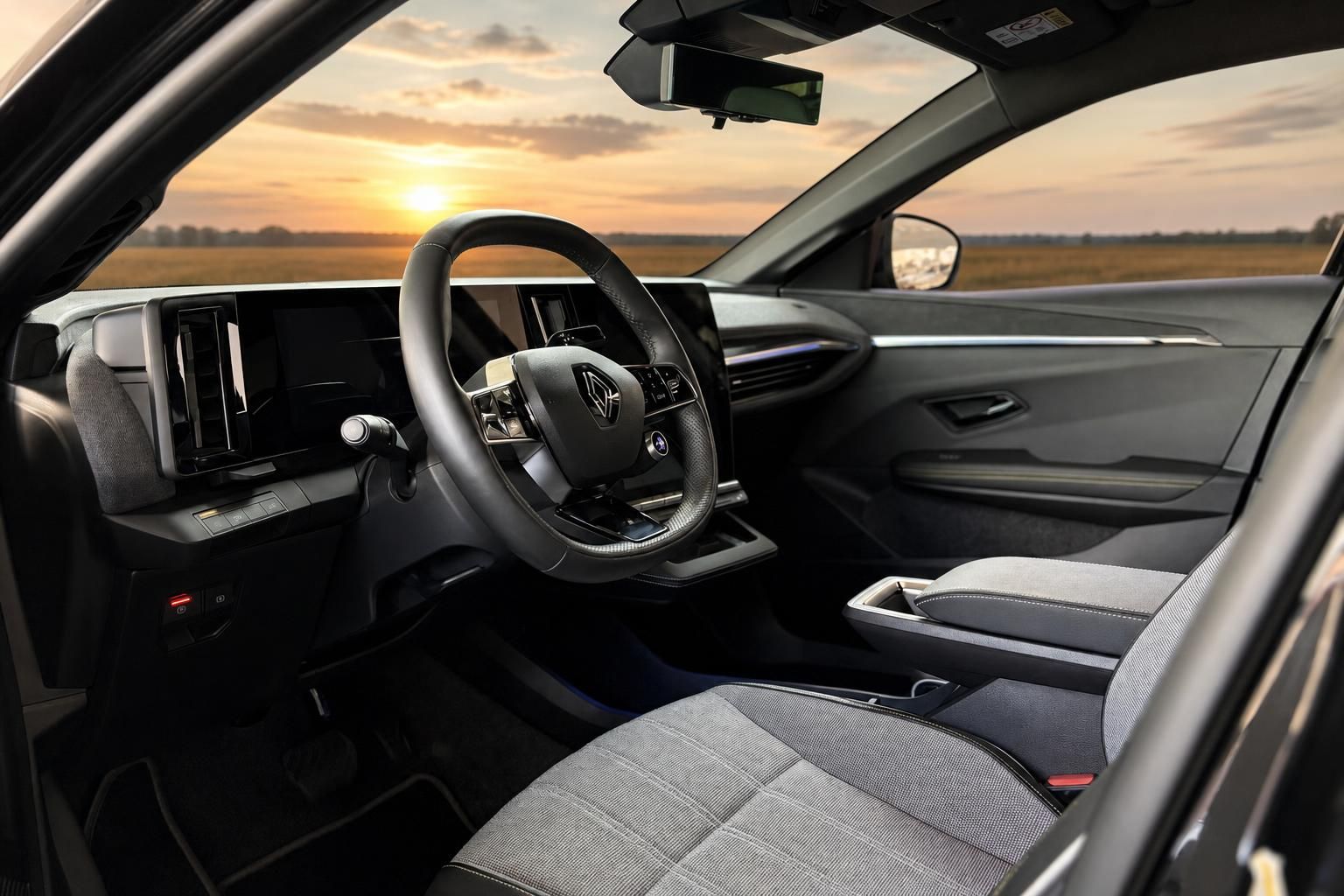 Renault Innenraum mit Lenkrad und Blick auf Sonnenuntergang über Feldern