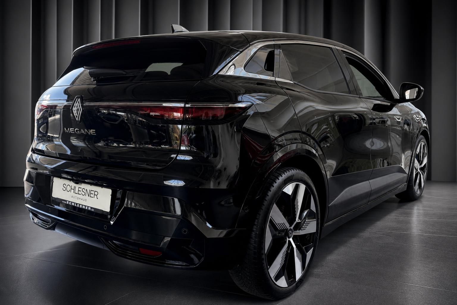 Renault Megane E-Tech in Schwarz, Heckansicht schraeg im Autohaus