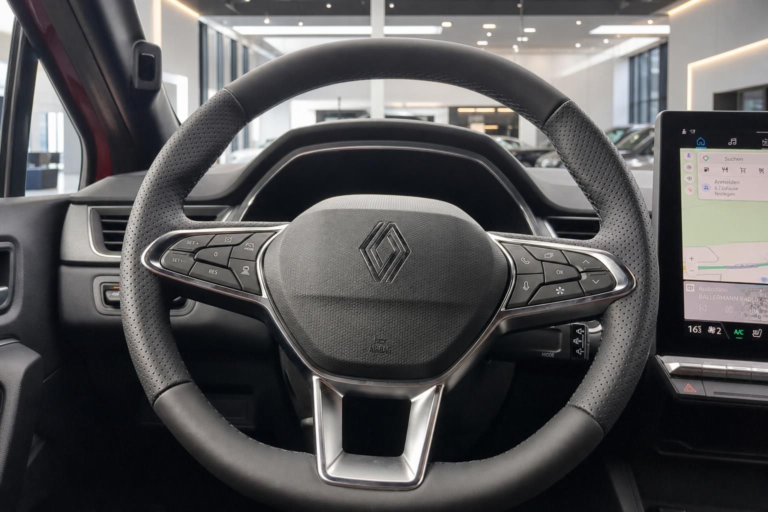 Renault Lenkrad mit Multifunktionstasten und Touchscreen-Infotainment im modernen Fahrzeuginnenraum
