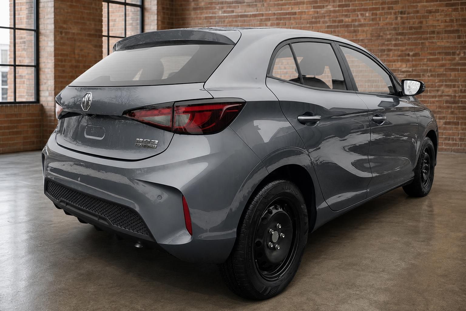 MG3 Hybrid+ in Grau, Heckansicht schraeg von hinten in Loft-Halle