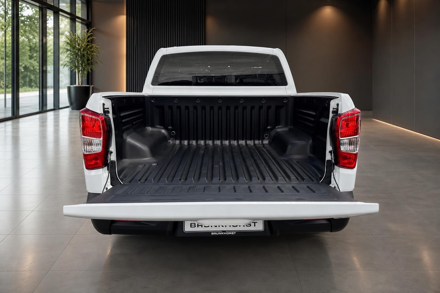 Weißer Pickup-Truck mit geöffneter Ladefläche im Autohaus-Showroom