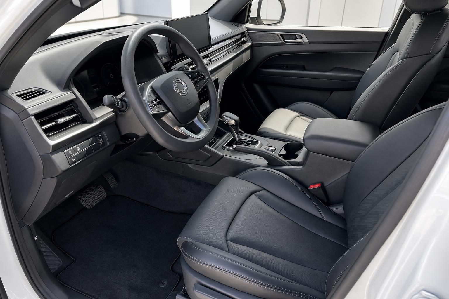 Fahrzeug-Innenraum mit dunklen Ledersitzen, Sportlenkrad und Mittelkonsole - Fahrerperspektive