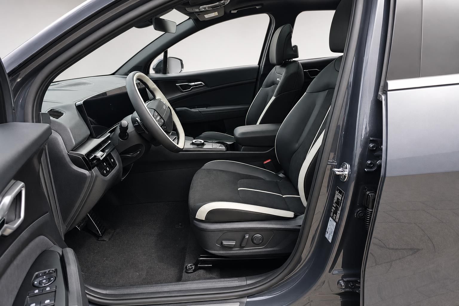 Kia Innenraum mit schwarz-weissen Ledersitzen und offener Fahrertuer