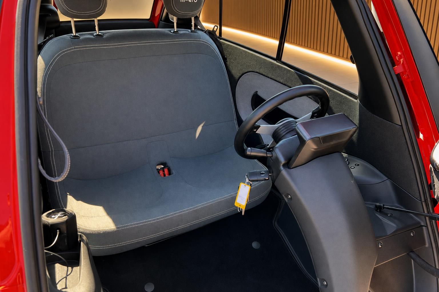 Innenraum des Microlino mit grauem Sitz und Lenkrad