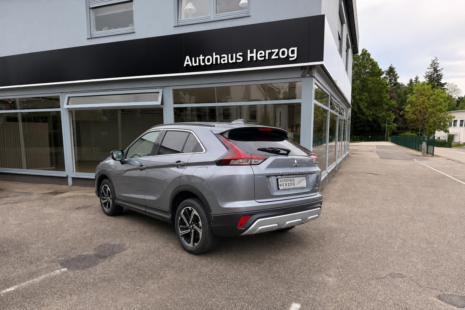Mitsubishi Eclipse Cross grauer SUV Schrägansicht hinten mit modernen LED-Rücklichtern im Showroom