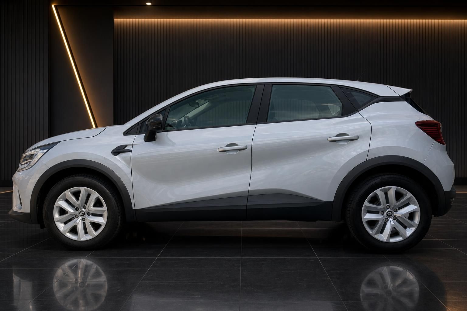 Renault Captur weiss Seitenansicht in modernem Autohaus