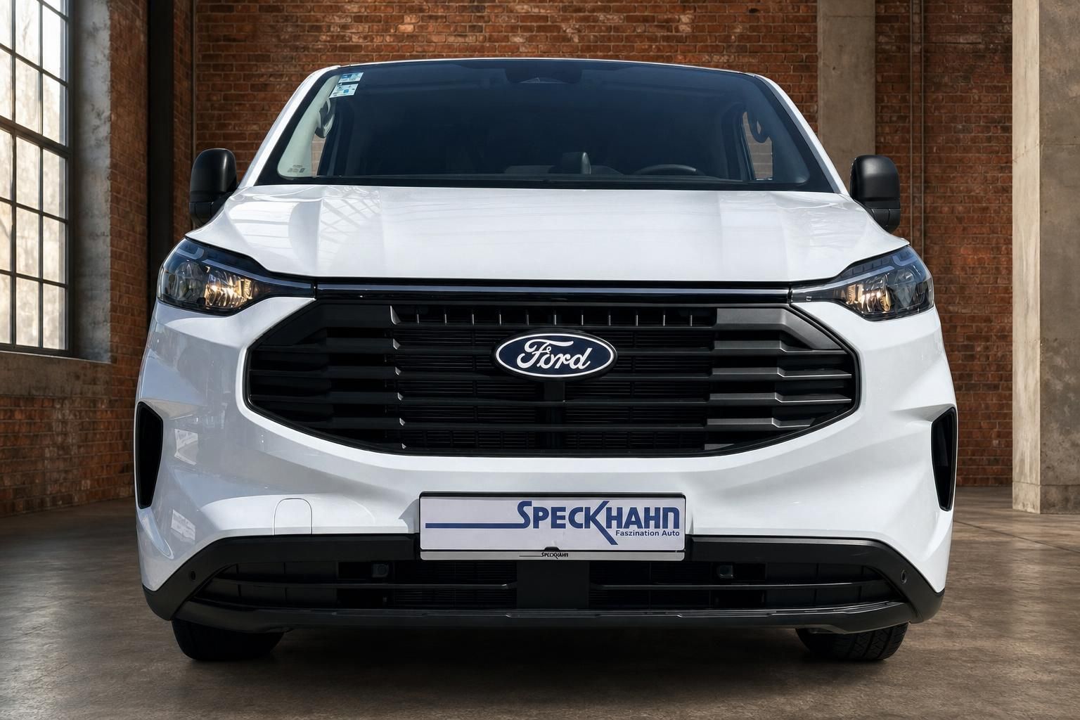 Ford Transit Custom weiss Frontansicht mit Speckhahn Kennzeichenhalter in Industriehalle