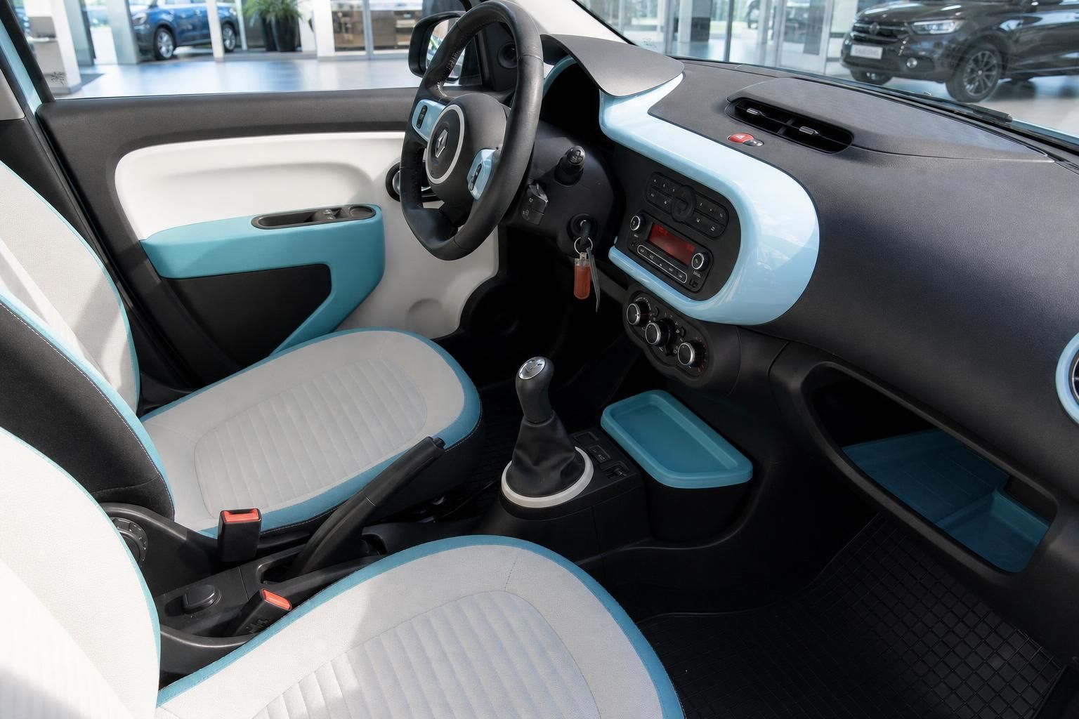 Renault Twingo Innenraum Fahrerseite mit hellblau-weißen Sitzen und Mittelkonsole