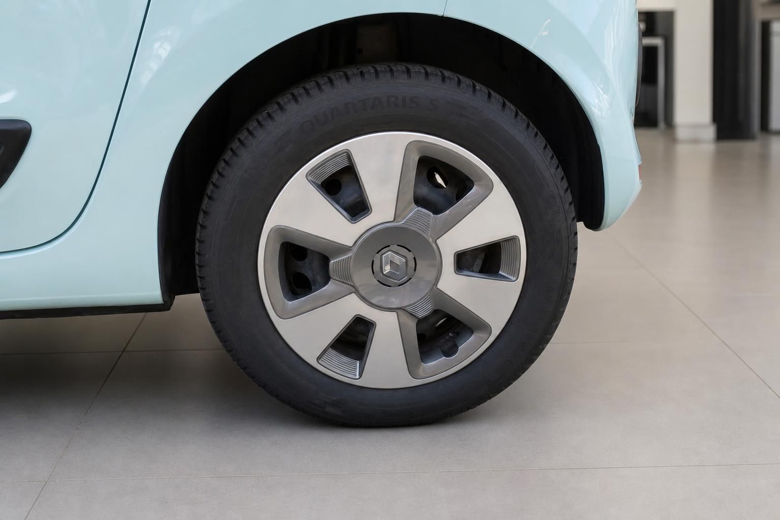Renault Twingo Felge mit Radkappe in Grau und hellblauer Karosserie im Autohaus