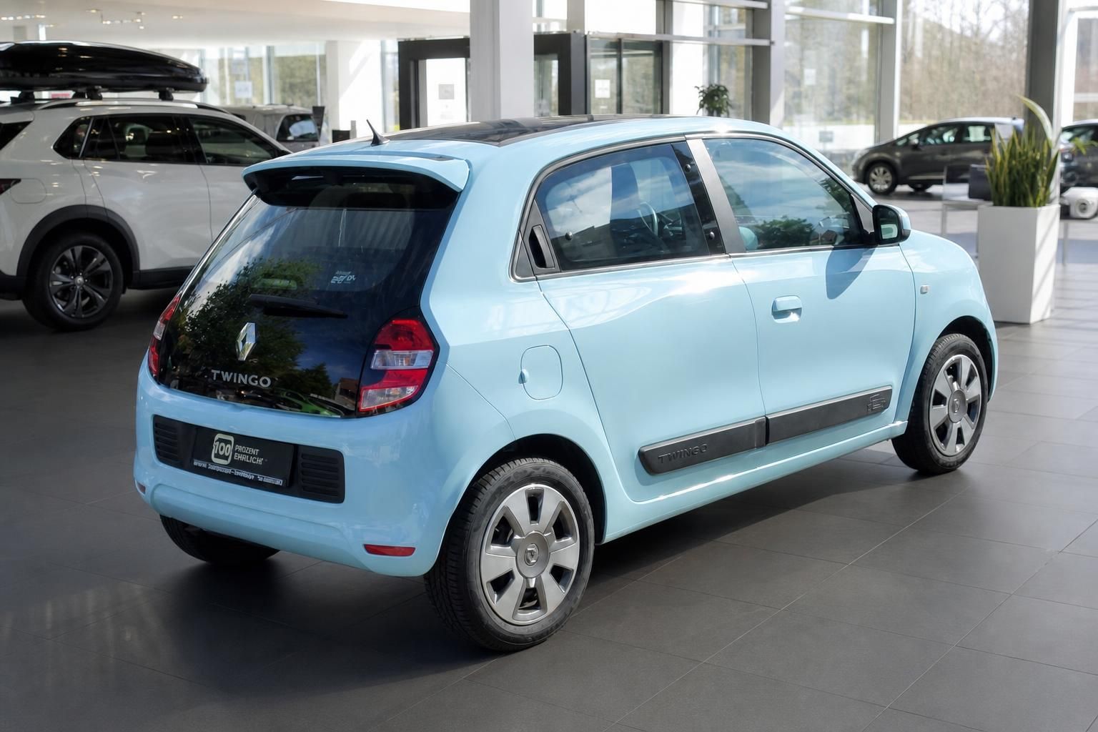Renault Twingo hellblau Heckansicht schräg im Autohaus – Kleinwagen mit dunklem Dach