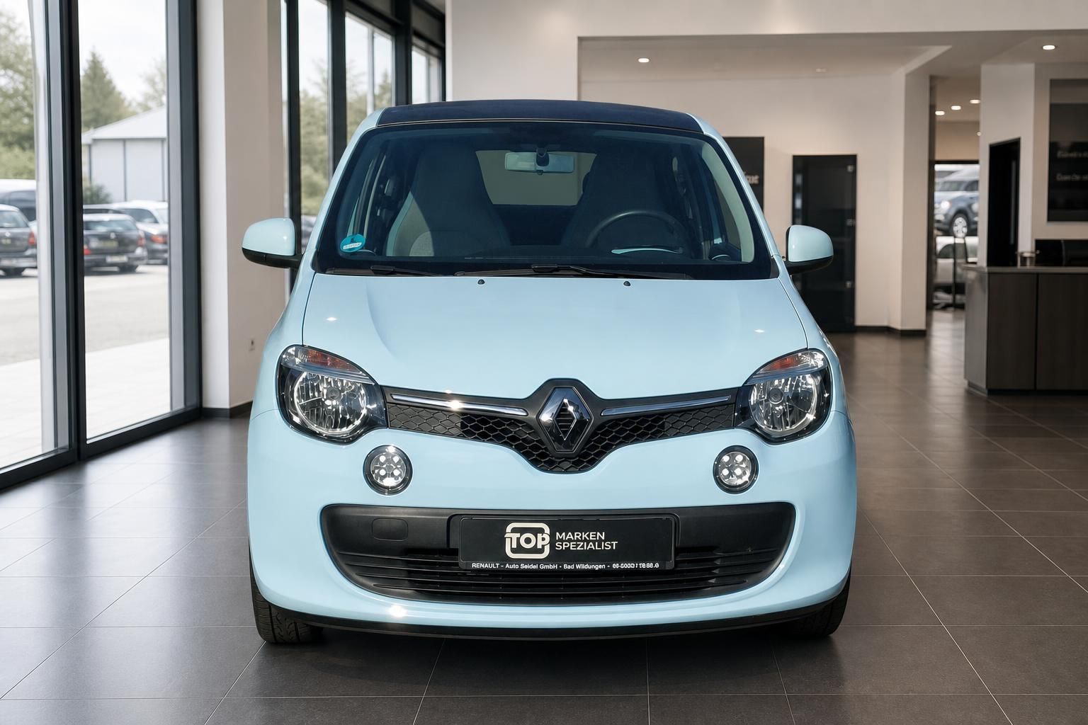 Renault Twingo hellblau Frontansicht im Showroom – Kleinwagen mit schwarzem Dach