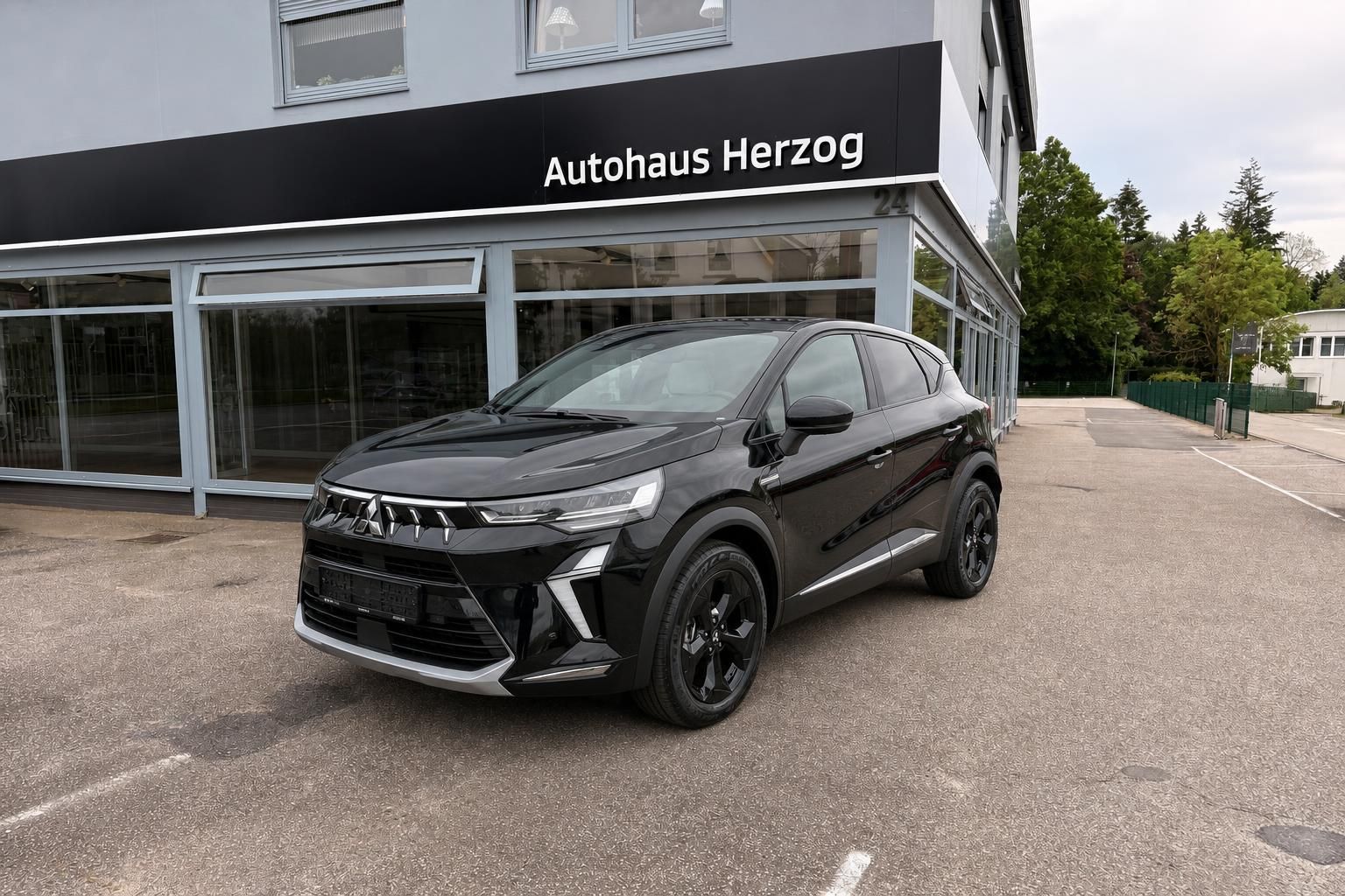 Schwarzes SUV Mitsubishi vor Autohaus Herzog in Frontansicht
