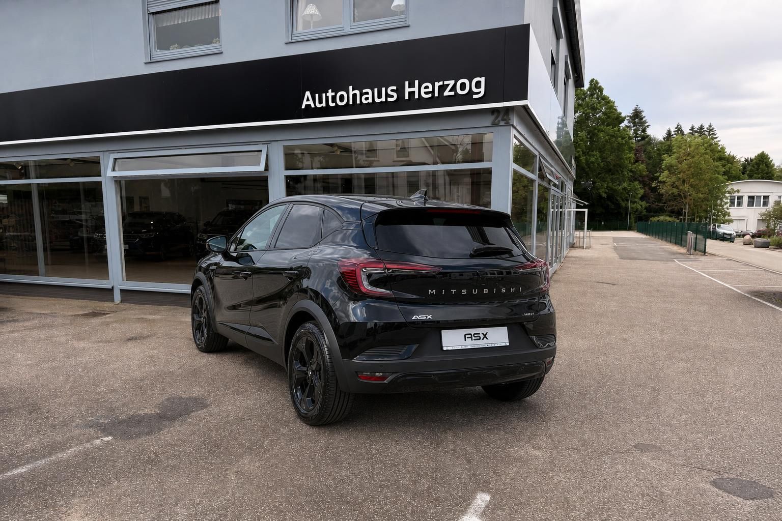 Mitsubishi ASX schwarz, Heckansicht seitlich vor Autohaus Herzog