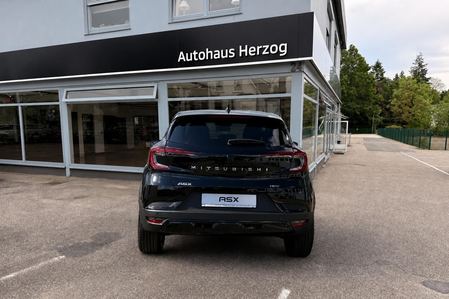 Mitsubishi ASX HEV schwarz, Heckansicht frontal vor Autohaus Herzog
