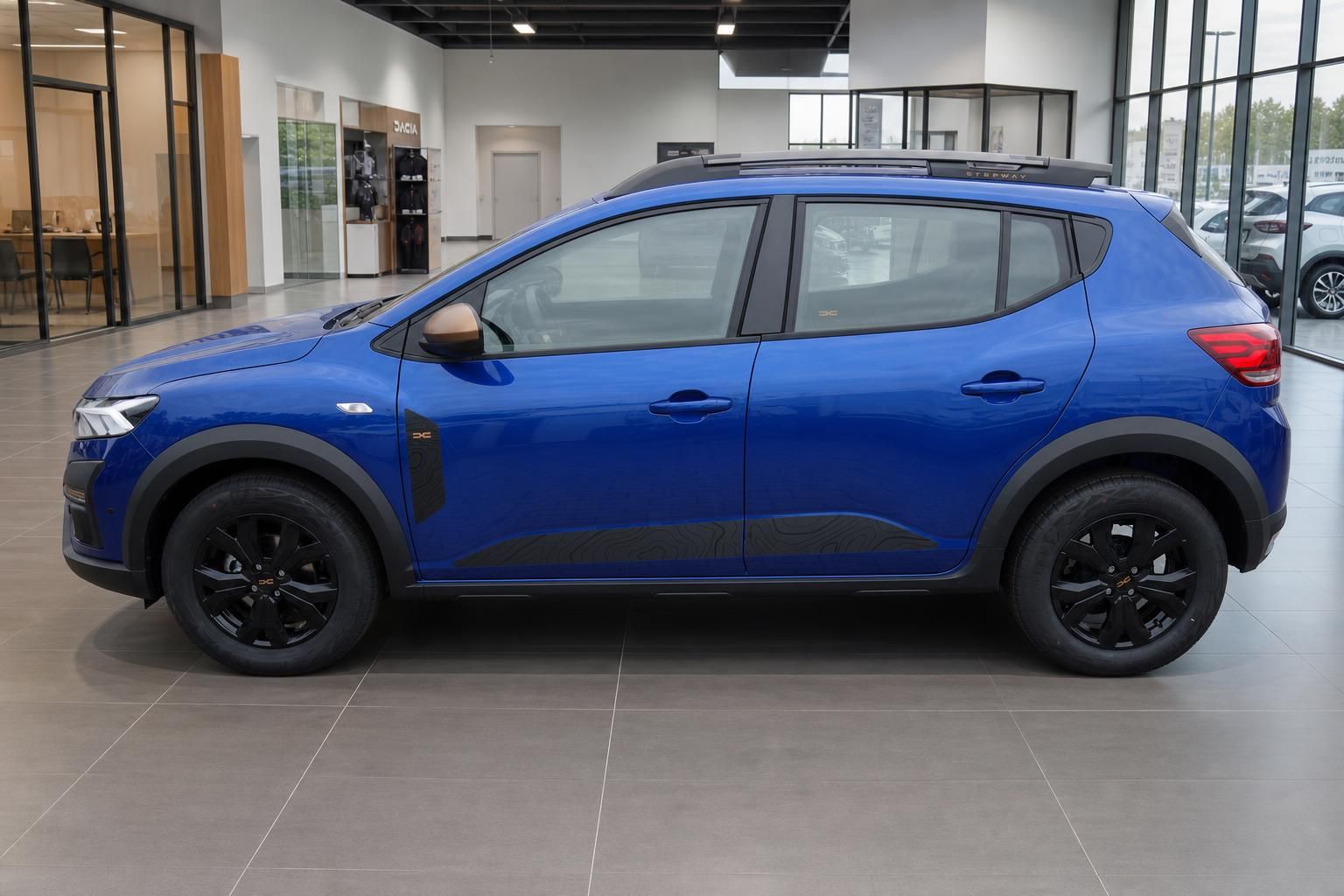 Blauer Dacia Sandero SUV Seitenansicht im Autohaus Showroom mit schwarzen Felgen