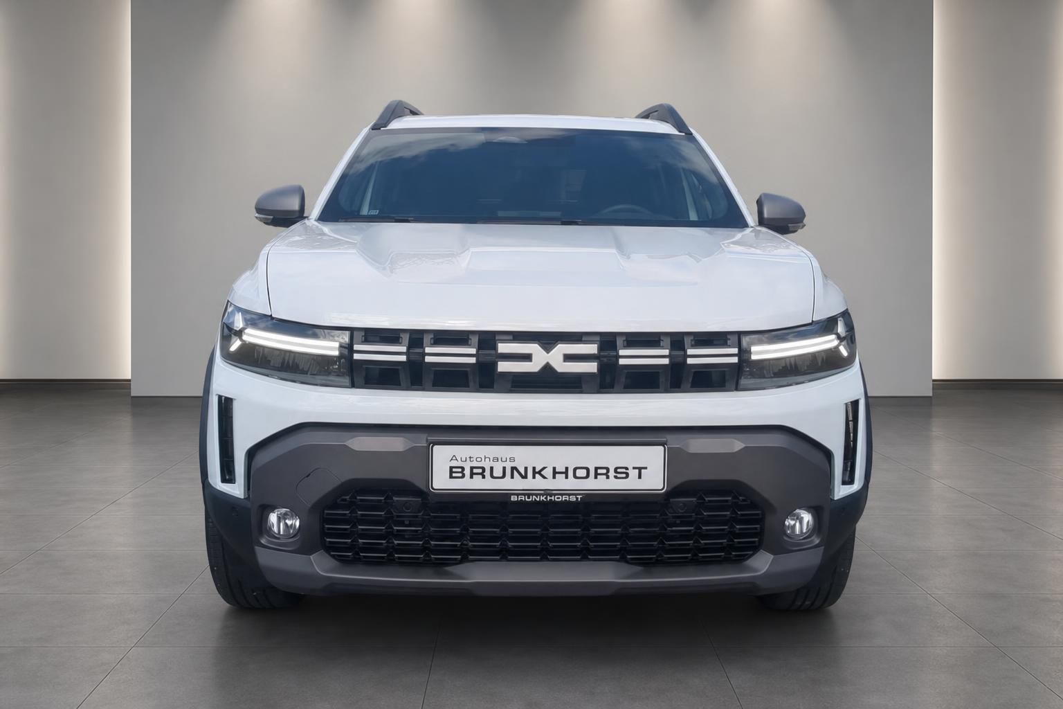 Dacia Duster weiß Frontansicht mit LED-Scheinwerfern im Showroom