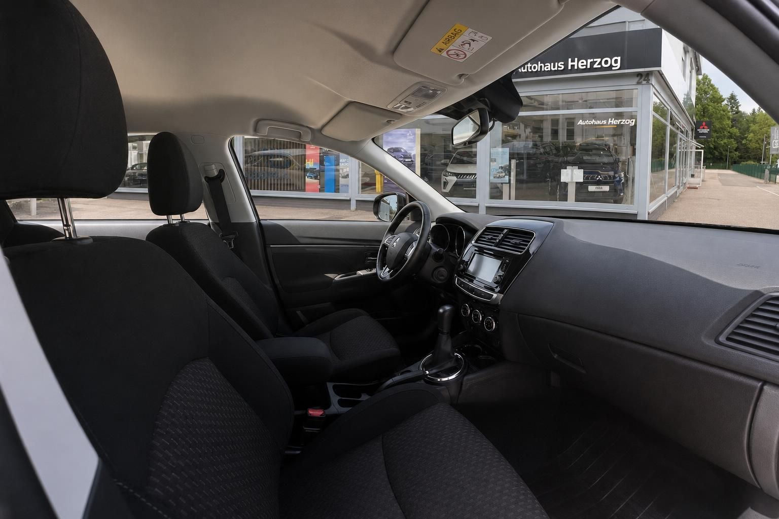 Mitsubishi ASX Innenraum – Vordersitze, Lenkrad und Mittelkonsole, Blick durch die Beifahrertür