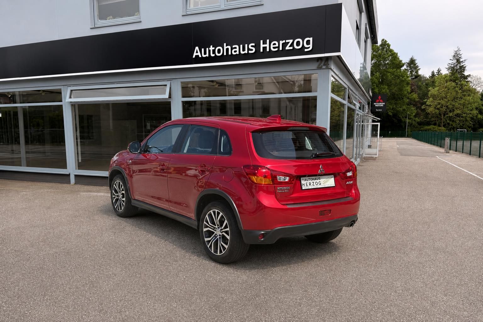 Mitsubishi ASX rot Heck-Seitenansicht rechts vor Autohaus Herzog – SUV kaufen