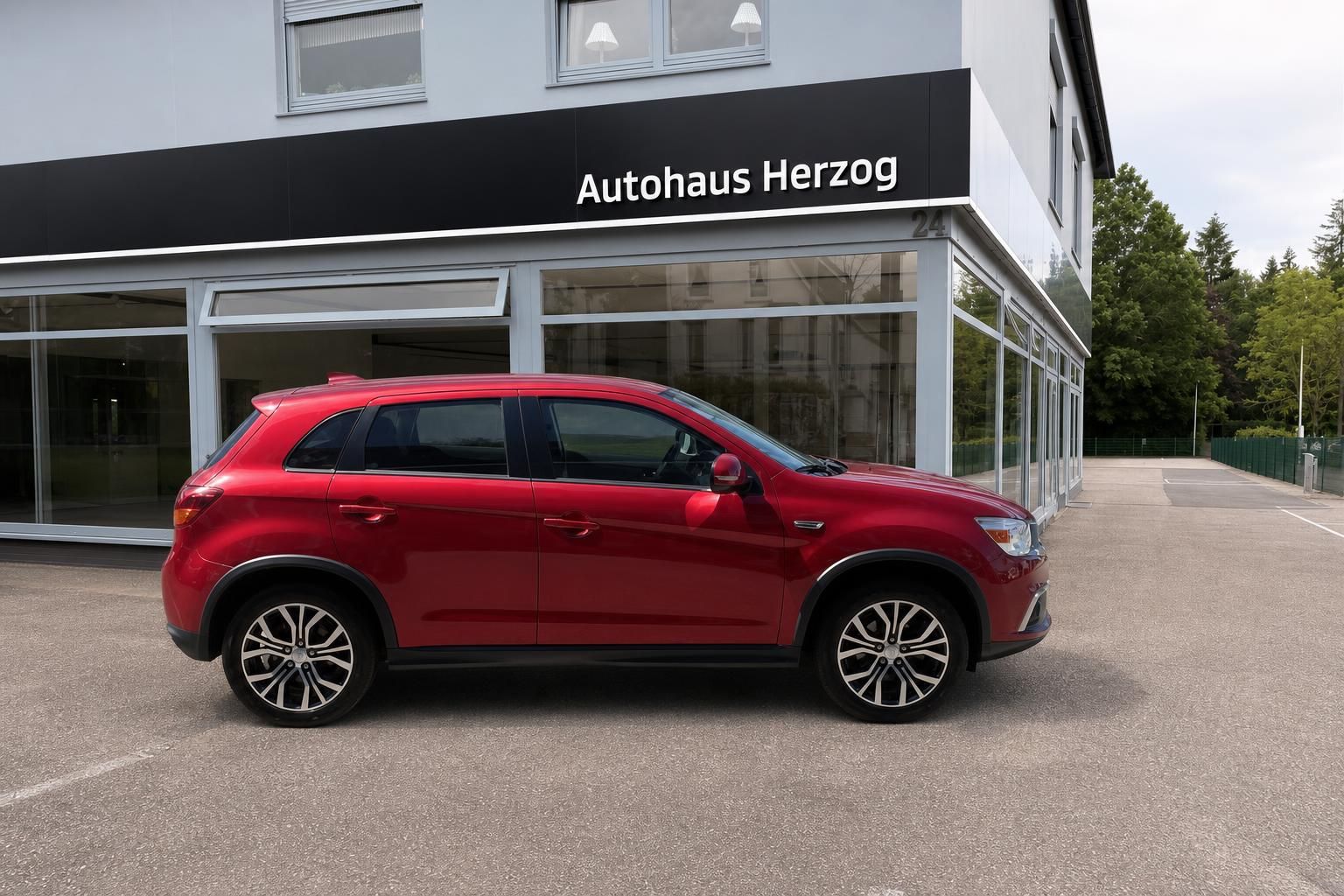 Mitsubishi ASX rot Seitenansicht rechts vor Autohaus Herzog – Kompakt-SUV kaufen