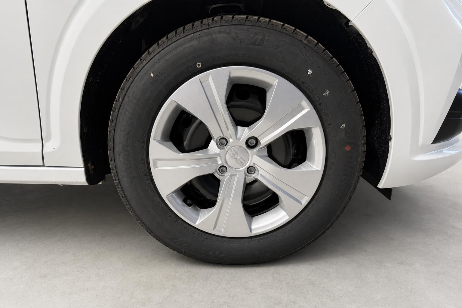 Detailansicht Leichtmetallfelge und Reifen eines weißen Fahrzeugs