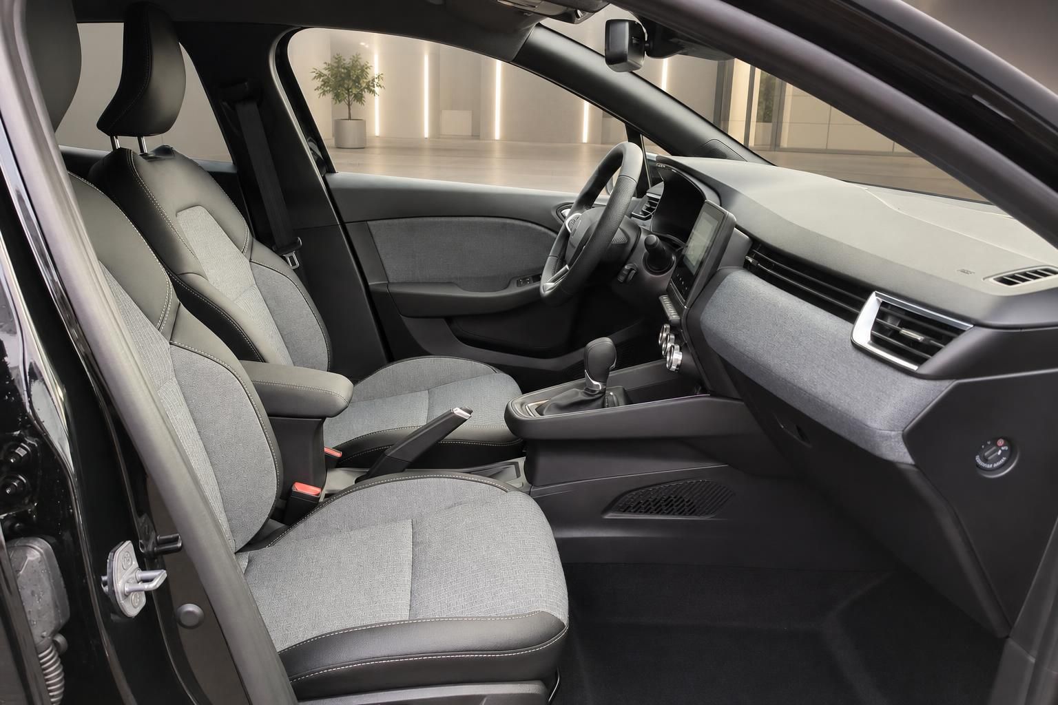 Vordersitze mit Stoffbezug und Schaltknauf im Innenraum eines modernen Automobils