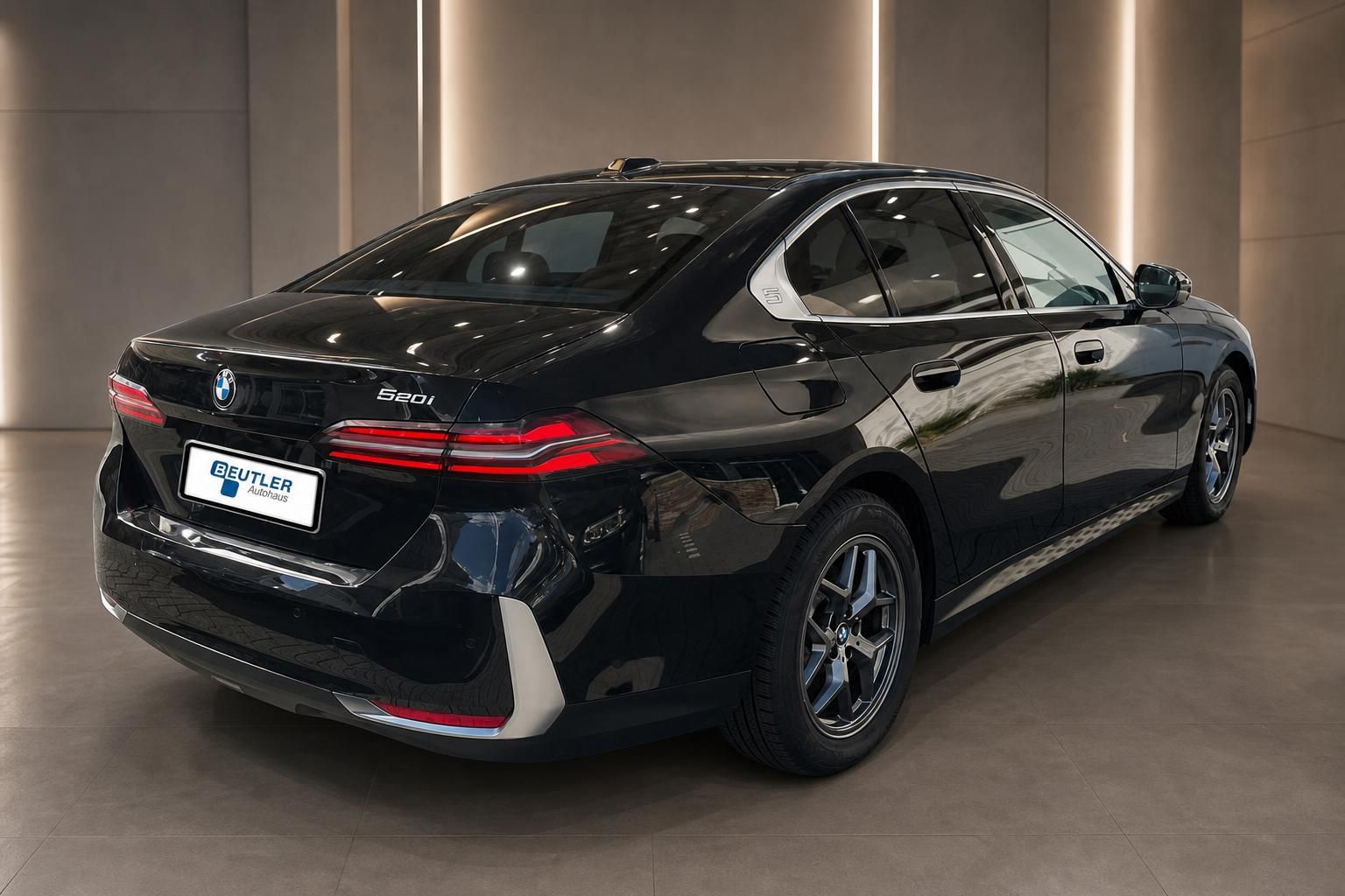 BMW 520i schwarz Heckansicht schraeg im Showroom